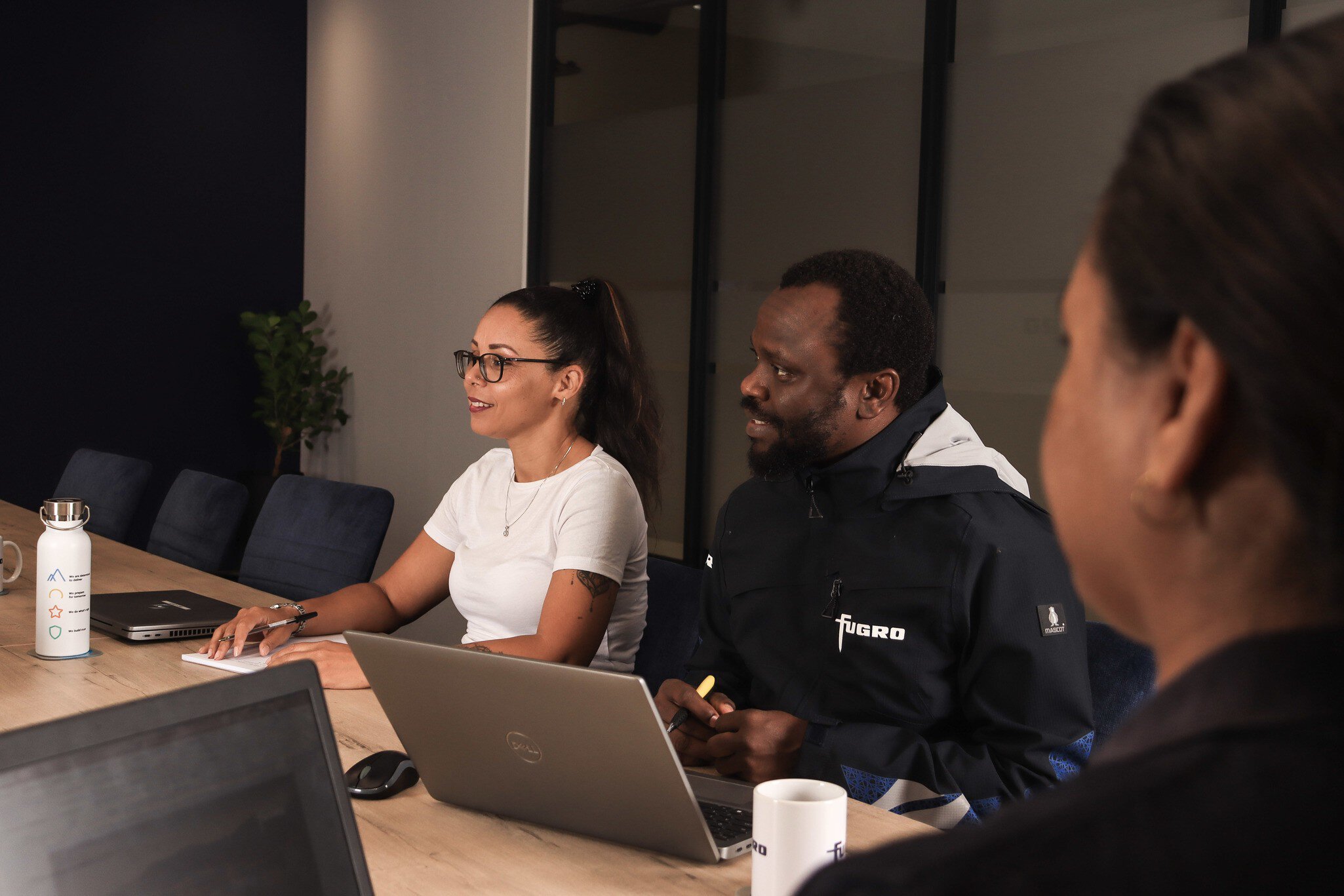 Employees having a discussion in a meeting room in the Cape Town office