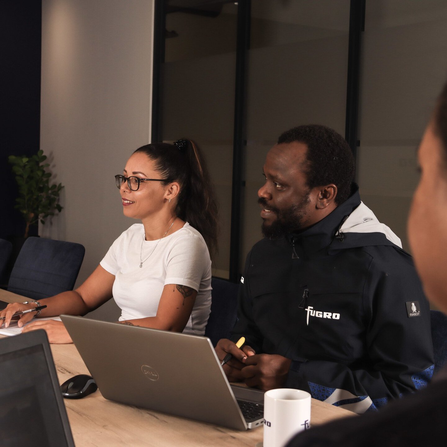 Employees having a discussion in a meeting room in the Cape Town office